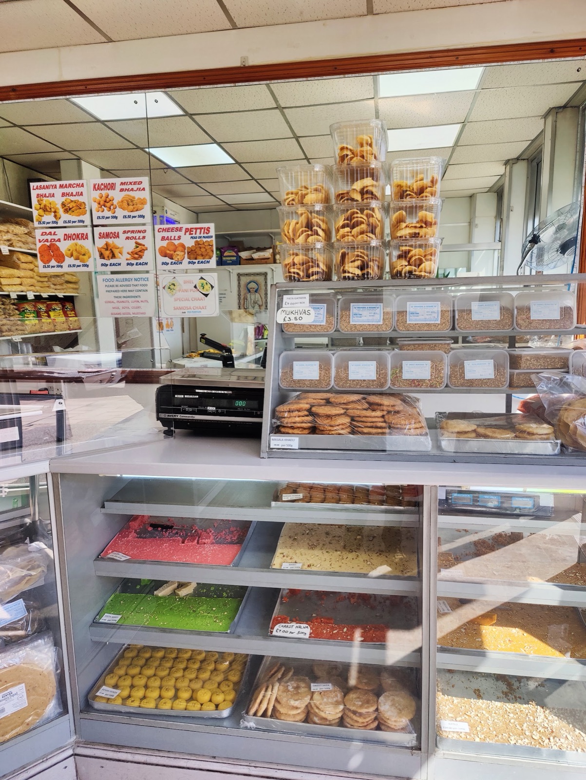 Inside Jalaram Sweet Mart: glass counters filled with sweets and savoury snacks