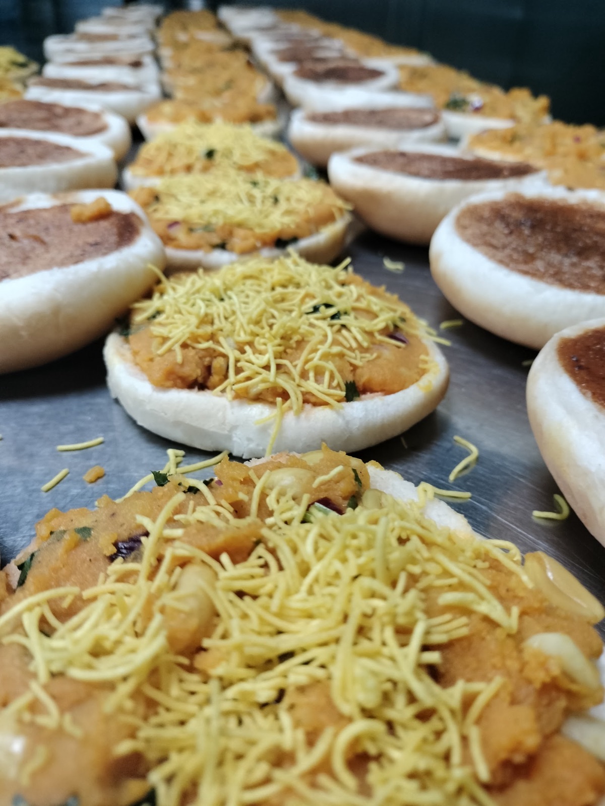 Chaat topped with sev, prepared in trays